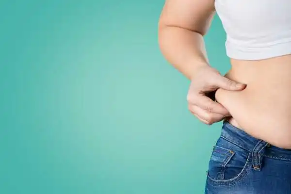 Image of woman pinching her love handles to show weight gain Thetford